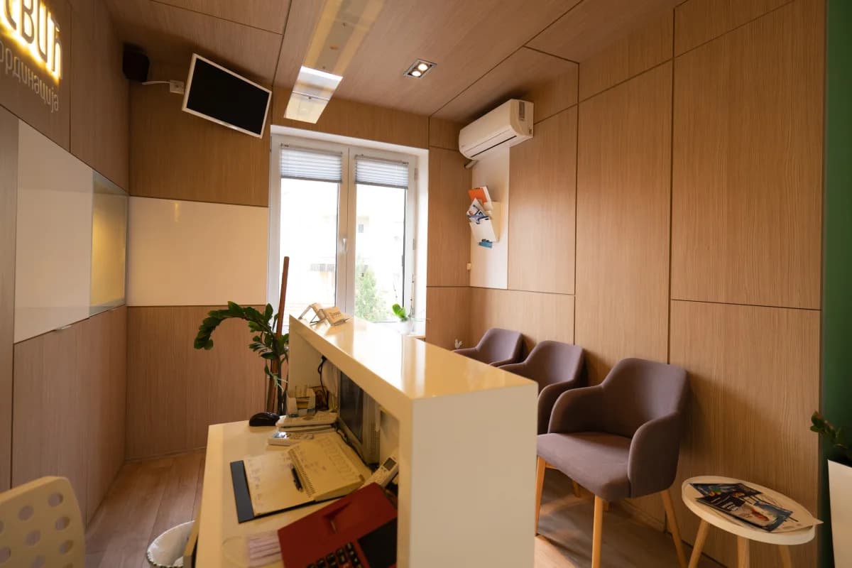 Waiting room: three armchairs along the wall, a side table with magazines and the reception desk