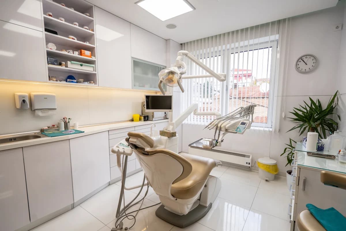 Treatment room with a dental chair, light and a screen beside it