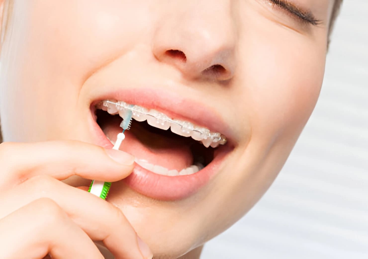 Osoba koja koristi interdentalnu četkicu za čišćenje zuba
